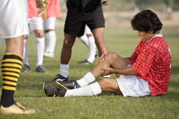 Soccer player holding injured knee