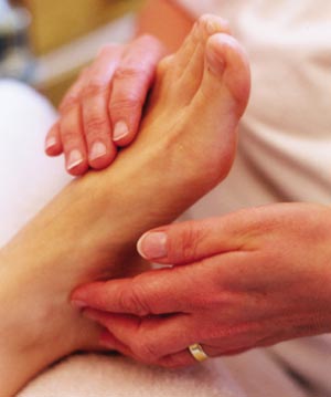 Patient receiving reflexology whilst student 'reads' the feet during treatment